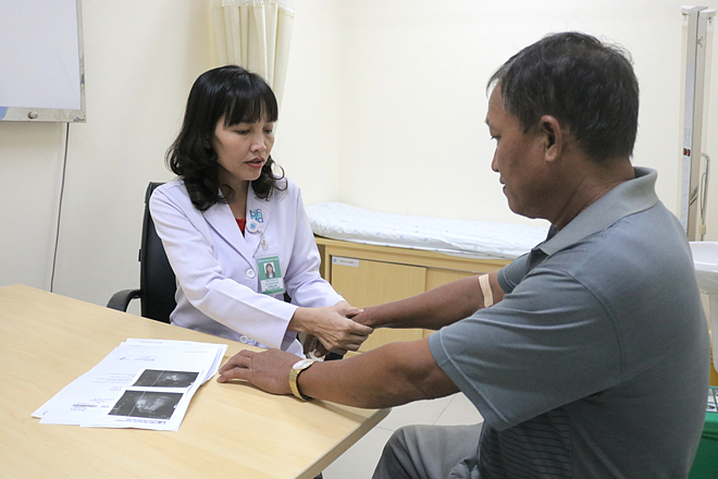 Bác sĩ đang thăm khám tình trạng biến dạng khớp ở cổ tay cho bệnh nhân. Ảnh bệnh viện cung cấp