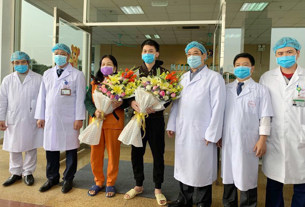 Bà Yên (người phụ nữ ôm hoa) trong ngày được ra viện.