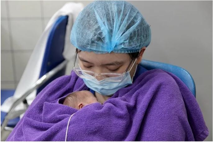 Một điều dưỡng thực hiện phương pháp Kangaroo da liền da cho trẻ sơ sinh.