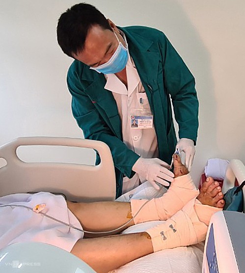 Tiến sĩ Trần Lê Đồng kiểm tra chân bệnh nhân ngày 5/5. Ảnh: Lê Phương.