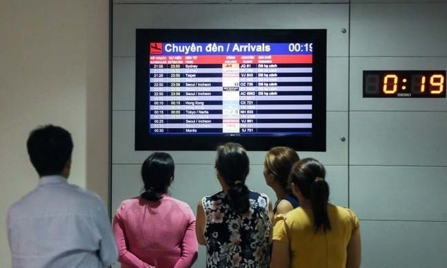Người dân theo dõi chuyến bay đến tại sân bay Tân Sơn Nhất, TP HCM ngày 18/1. Ảnh: Quỳnh Trần.