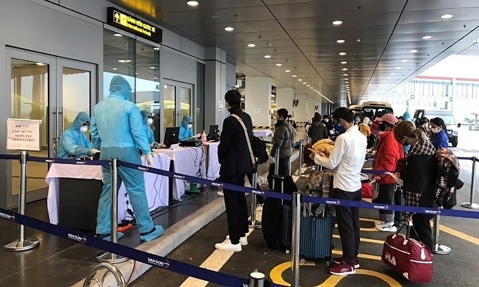 Passengers wait in line for health-check procedures at Van Don International Airport in Quang Ninh, March 2020. Photo by VnExpress/Binh Minh.