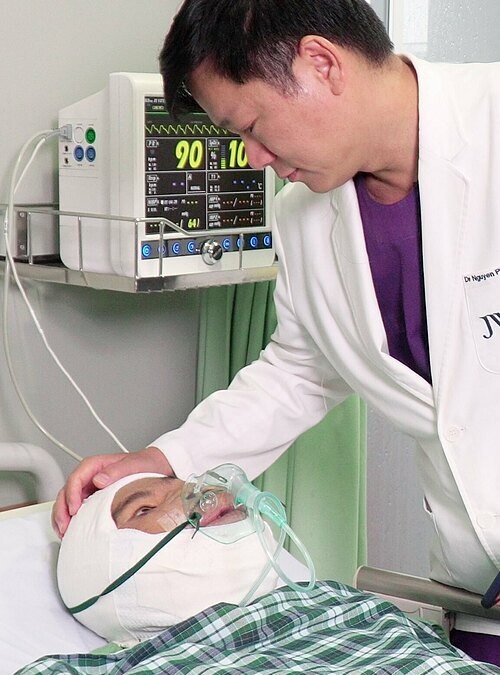 Sau ca mổ ngày 19/9, dù còn băng bó nhưng gương mặt anh Mến thon gọn hơn rất nhiều, thấy được khuôn miệng. Ảnh: Hải Đăng.